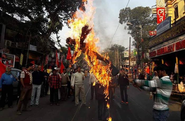 indian men buring an effigy during protests