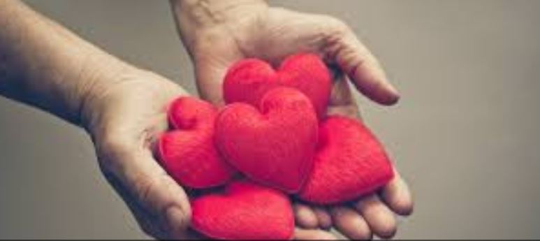 Two hands hold red hearts: compassion